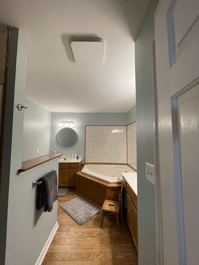 full bathroom with a bath, wood finished floors, and vanity