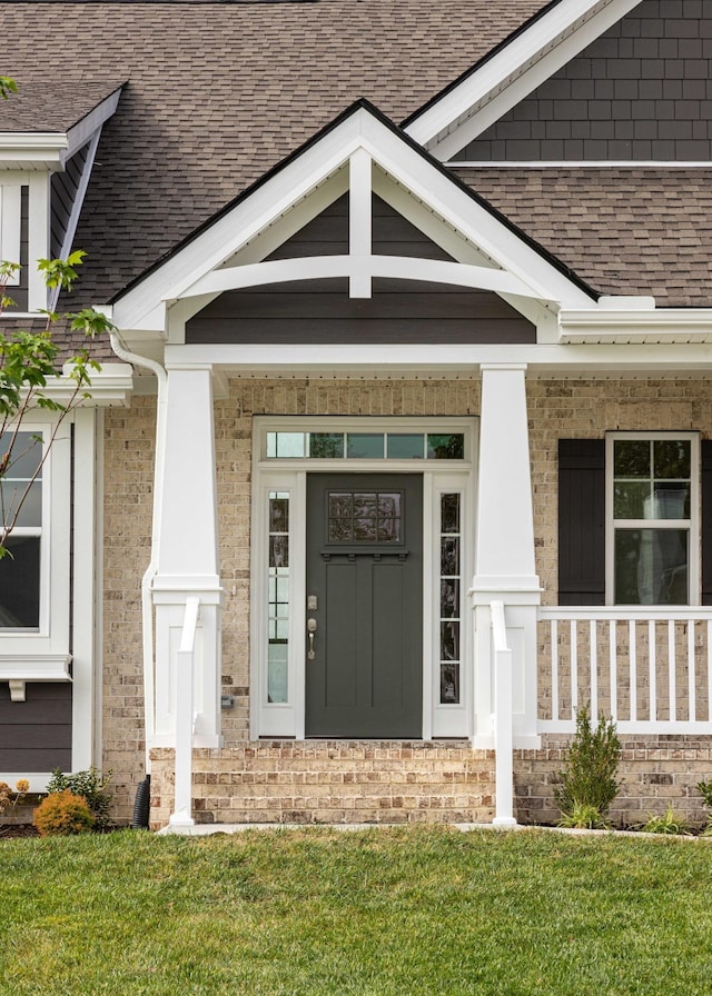 entrance to property with a lawn and a porch