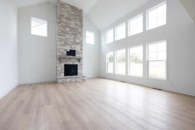 unfurnished living room with a fireplace, plenty of natural light, and light hardwood / wood-style flooring