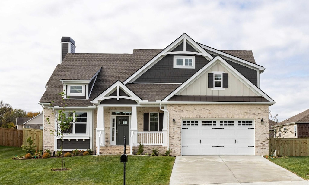 craftsman-style house featuring a front lawn, covered porch, and a garage