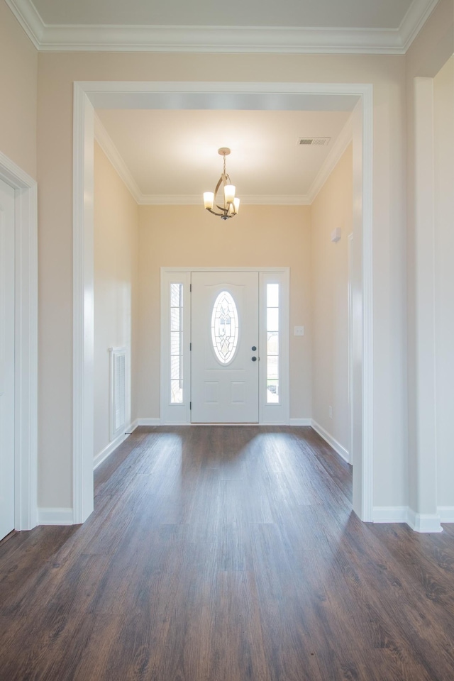 foyer entrance featuring dark hardwood / wood-style flooring, crown molding, and a notable chandelier