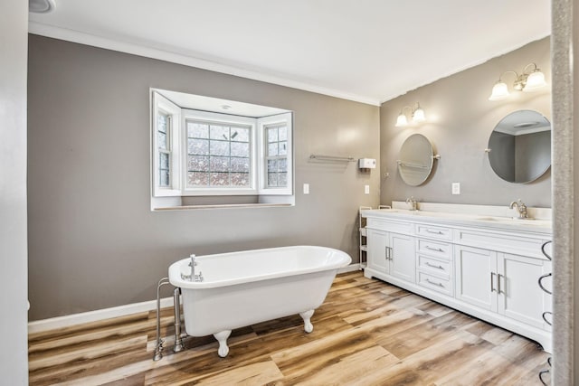 bathroom featuring vanity, a tub to relax in, hardwood / wood-style flooring, and crown molding