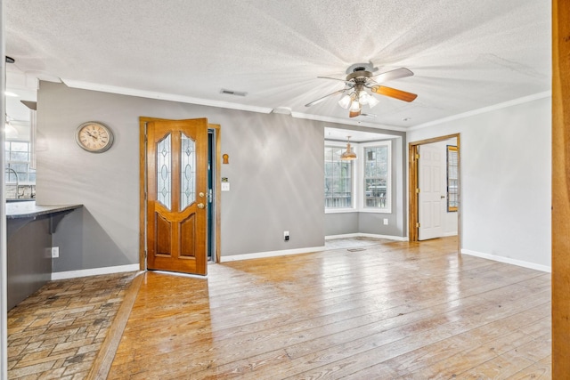 foyer featuring ceiling fan, ornamental molding, a textured ceiling, and light hardwood / wood-style flooring