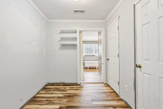 hallway with hardwood / wood-style flooring and crown molding