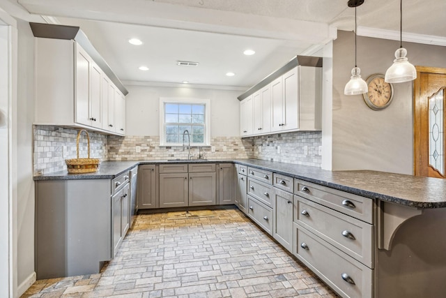 kitchen with pendant lighting, sink, ornamental molding, tasteful backsplash, and kitchen peninsula