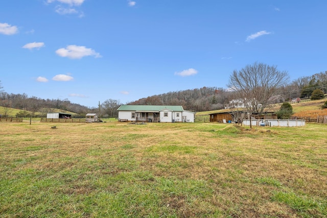 view of yard with a rural view and an outdoor structure