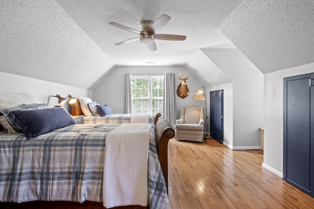 bedroom featuring hardwood / wood-style floors, ceiling fan, and lofted ceiling