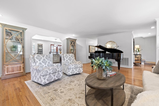 living room featuring light hardwood / wood-style flooring and ornamental molding