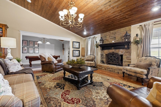 living room featuring wood ceiling, vaulted ceiling, hardwood / wood-style floors, a stone fireplace, and pool table