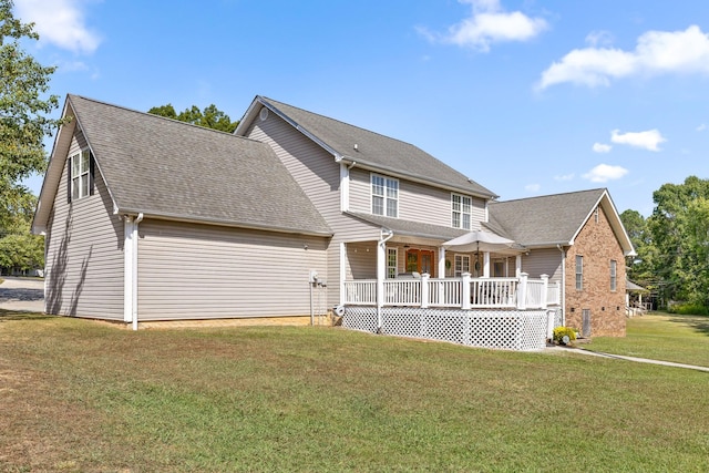 back of house with covered porch and a yard