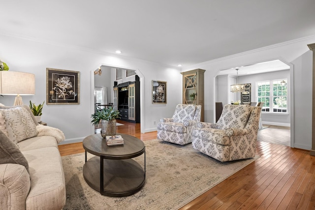 living room with hardwood / wood-style floors, a chandelier, and ornamental molding