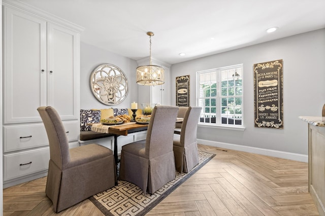 dining room with breakfast area, an inviting chandelier, and light parquet flooring