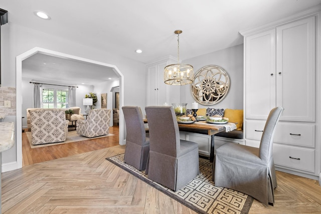 dining room with breakfast area, light parquet flooring, and a chandelier