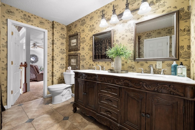 bathroom with tile patterned flooring, vanity, a textured ceiling, and toilet