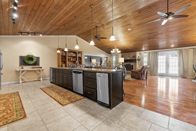 kitchen with track lighting, dark brown cabinetry, stainless steel appliances, decorative light fixtures, and a breakfast bar area