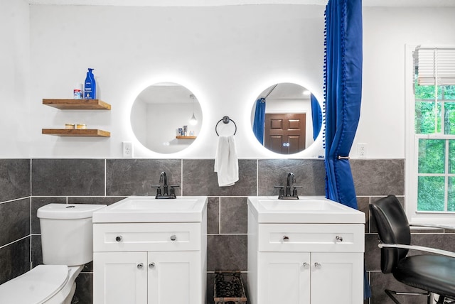 bathroom with vanity, toilet, and tile walls