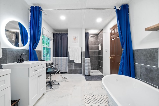 bathroom featuring vanity, tile walls, and independent shower and bath