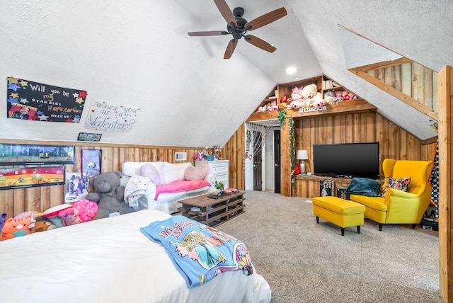 carpeted bedroom with a textured ceiling, ceiling fan, lofted ceiling, and wood walls