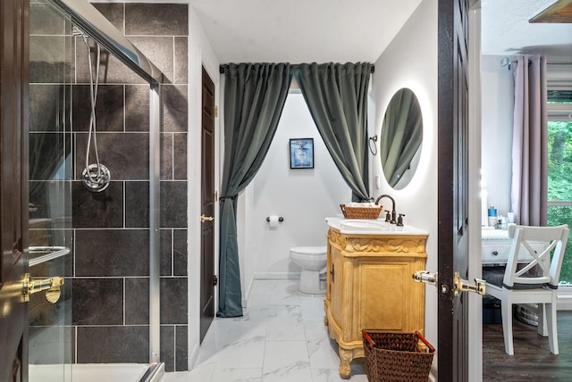 bathroom with vanity, a shower with shower door, and toilet