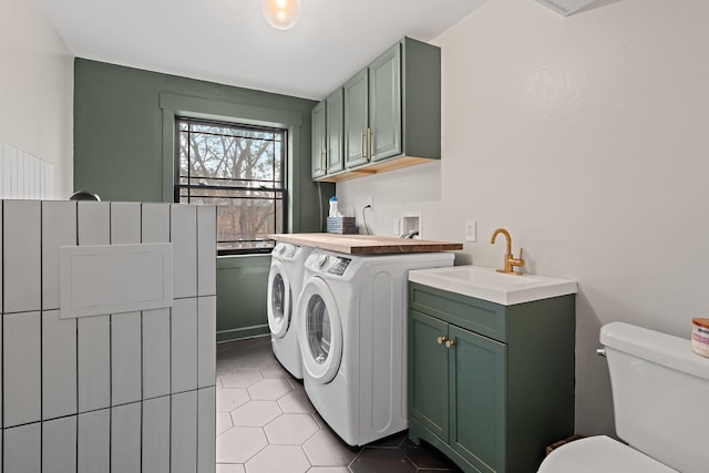 laundry area with washing machine and clothes dryer, sink, and light tile patterned floors