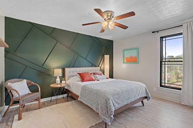 bedroom featuring ceiling fan, a textured ceiling, and hardwood / wood-style flooring