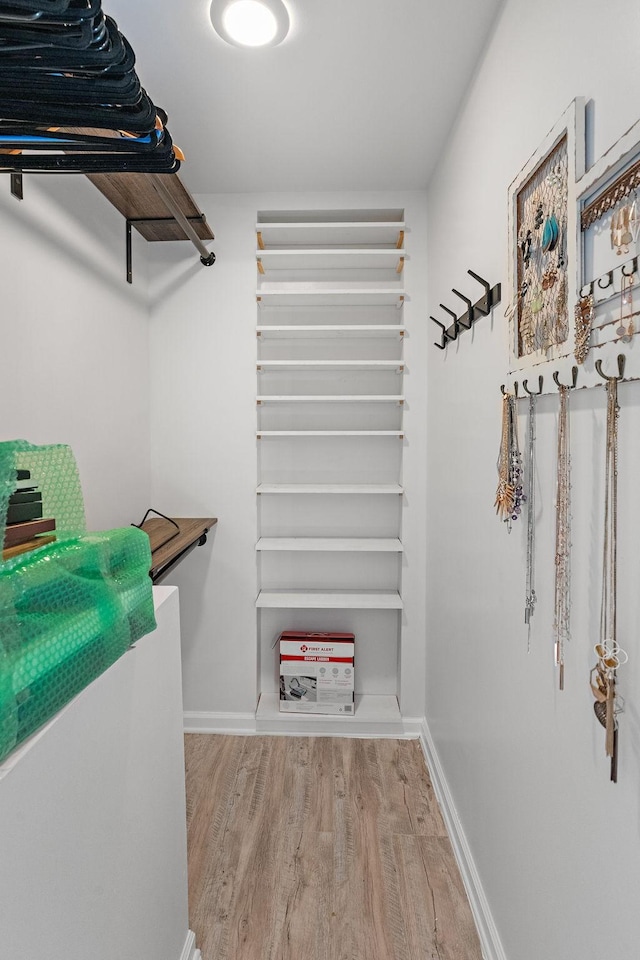 spacious closet with light hardwood / wood-style flooring