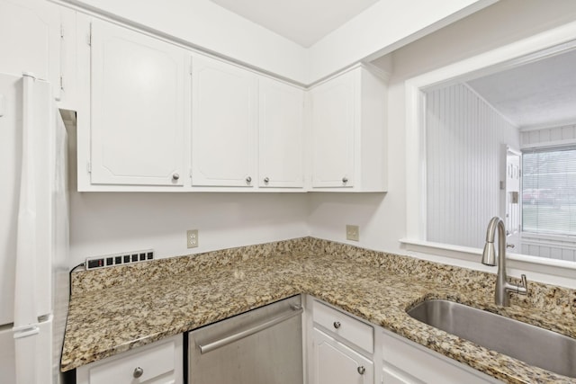 kitchen featuring white cabinets, white fridge, light stone countertops, and sink