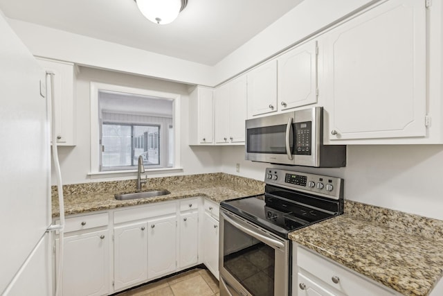 kitchen with light stone counters, white cabinetry, sink, and appliances with stainless steel finishes