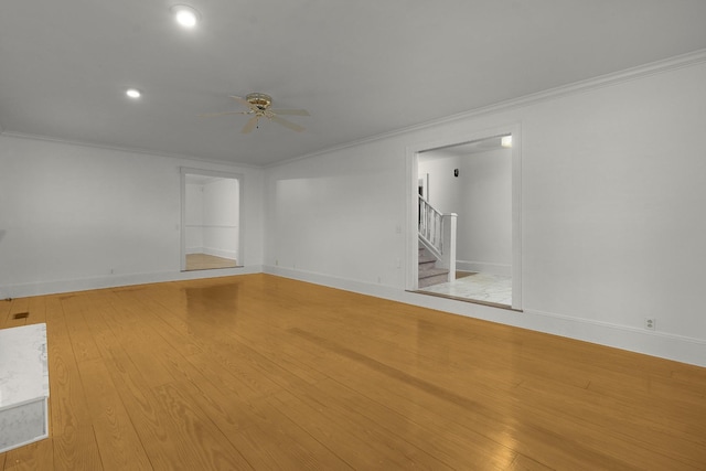 empty room with ceiling fan, light wood-type flooring, and crown molding