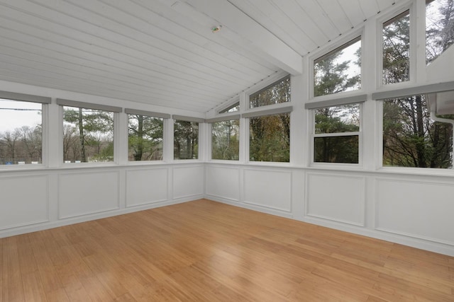 unfurnished sunroom featuring vaulted ceiling with beams