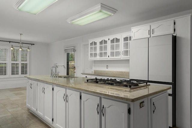 kitchen featuring white cabinets, a kitchen island with sink, stainless steel gas stovetop, and sink