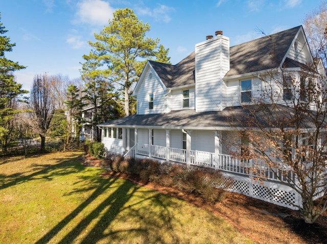 view of side of home with a yard and a porch