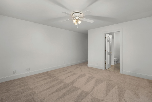 spare room with ceiling fan and light colored carpet