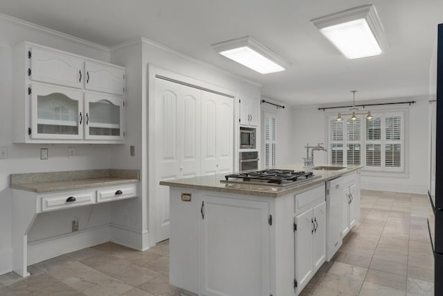 kitchen featuring appliances with stainless steel finishes, pendant lighting, a center island with sink, white cabinets, and ornamental molding