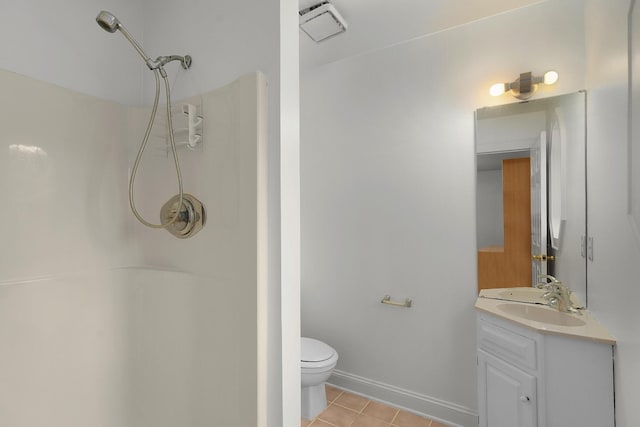 bathroom with tile patterned floors, toilet, vanity, and walk in shower