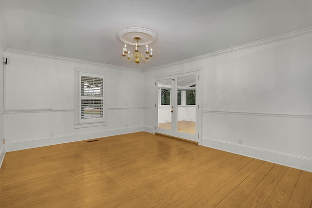 unfurnished room with light hardwood / wood-style flooring, a chandelier, french doors, and ornamental molding