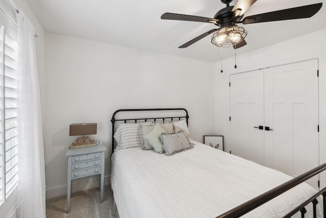 carpeted bedroom with ceiling fan and a closet