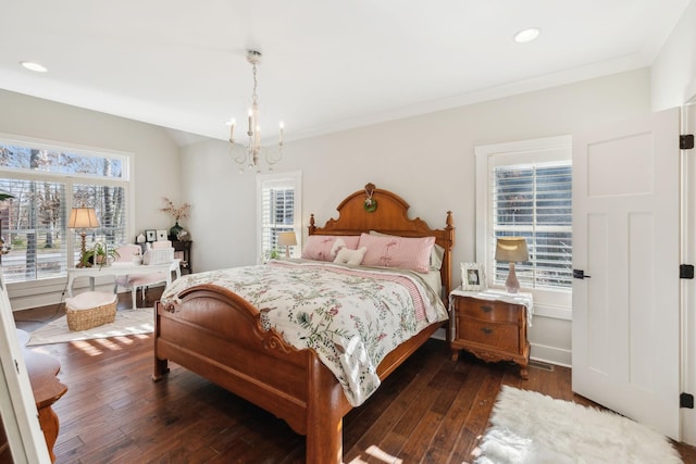 bedroom featuring a chandelier, dark hardwood / wood-style floors, and ornamental molding