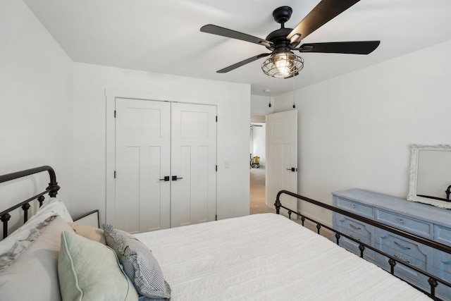 carpeted bedroom featuring ceiling fan and a closet