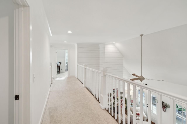 corridor featuring light carpet and vaulted ceiling