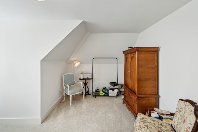 living area featuring light colored carpet and lofted ceiling