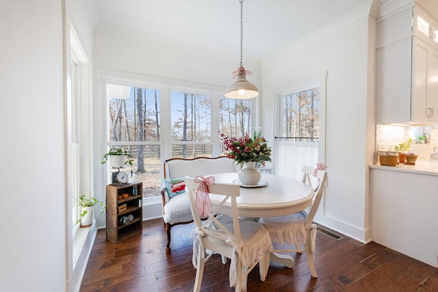 dining area with dark hardwood / wood-style flooring and ornamental molding