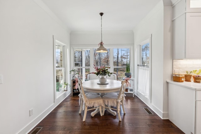 dining room with dark hardwood / wood-style floors and ornamental molding