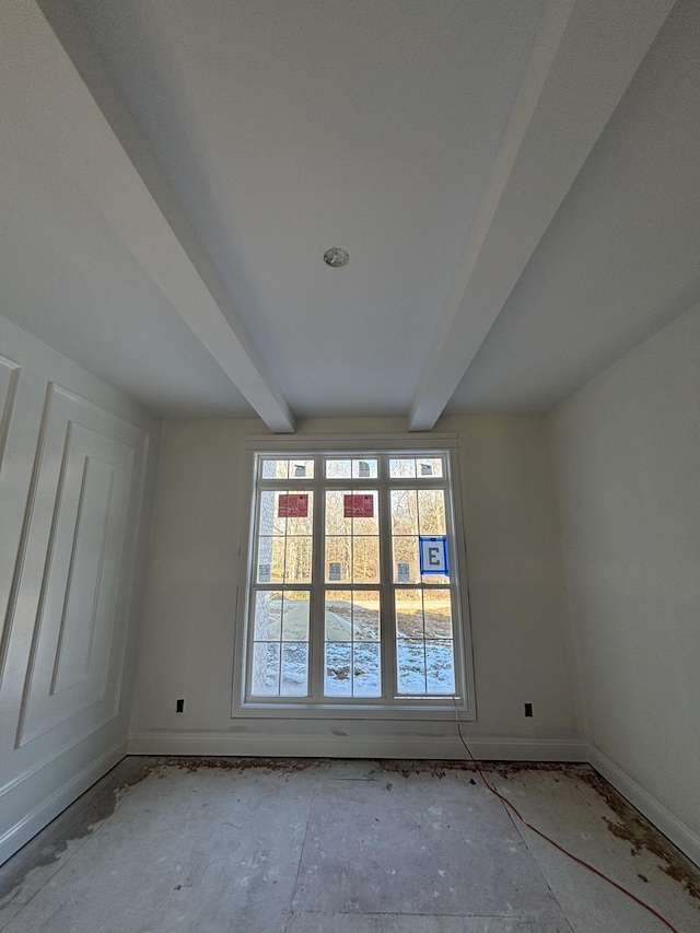 spare room with beamed ceiling