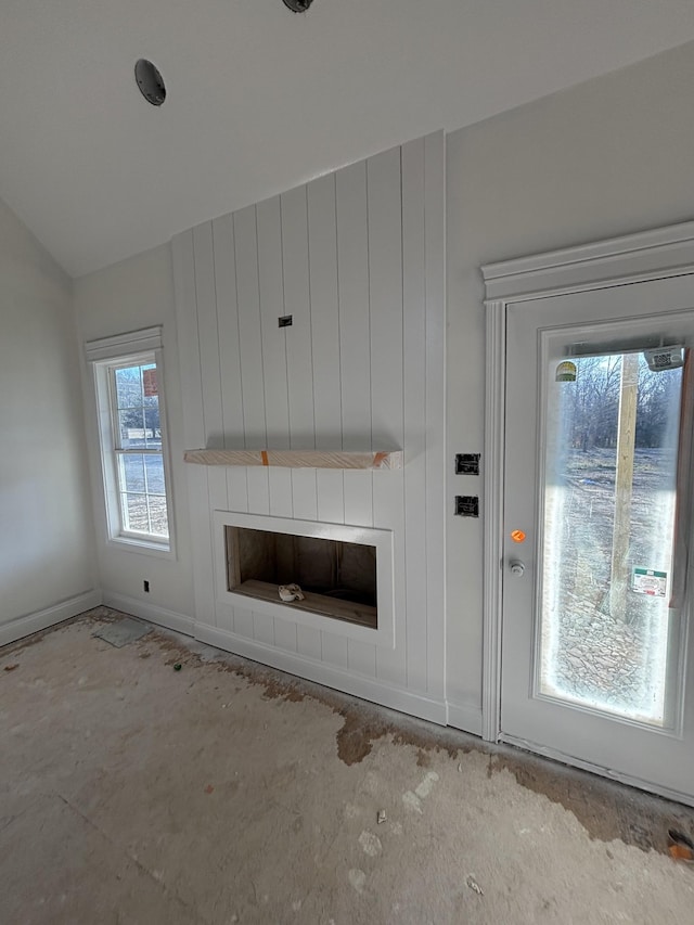 unfurnished living room featuring a large fireplace and a wealth of natural light