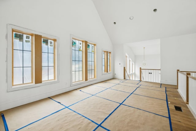 interior space featuring light hardwood / wood-style floors, high vaulted ceiling, and an inviting chandelier