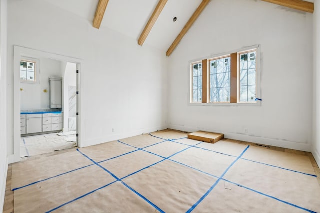 unfurnished bedroom with beam ceiling and high vaulted ceiling