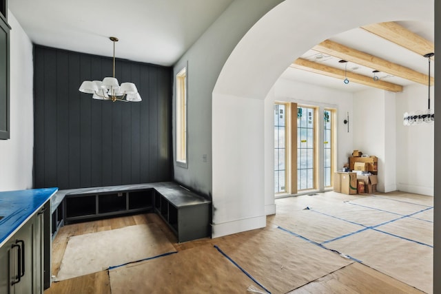 mudroom featuring beam ceiling, hardwood / wood-style flooring, and a notable chandelier