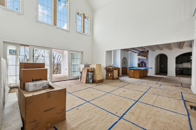 interior space with beamed ceiling and high vaulted ceiling