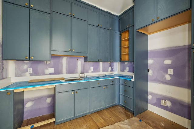 kitchen with decorative backsplash, dark hardwood / wood-style flooring, and blue cabinetry